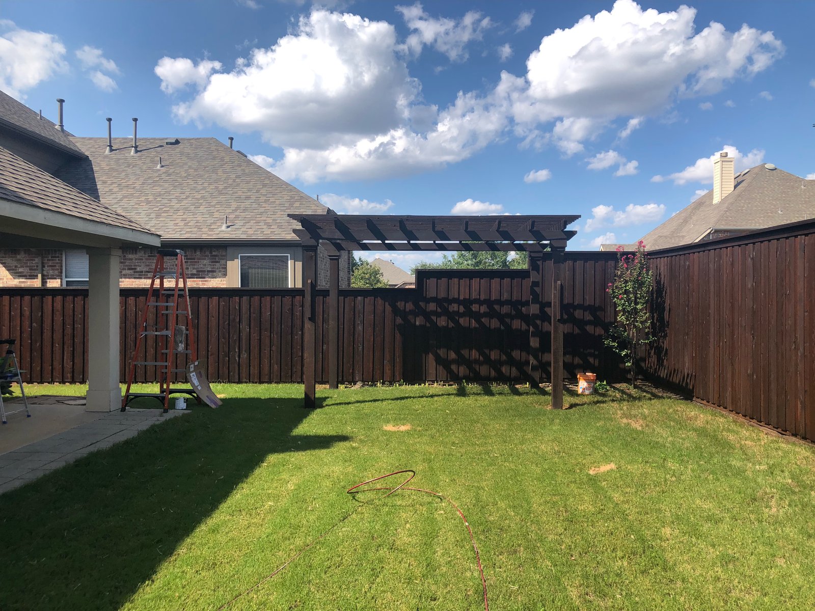 Freshly stained backyard fence and pergola